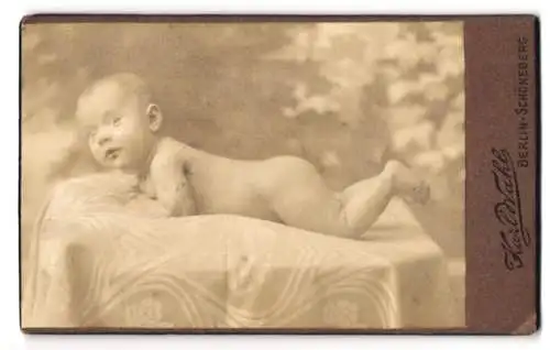 Fotografie Karl Wahl, Berlin-Schöneberg, Hauptstrasse 156, liegendes Baby auf Stofftuch