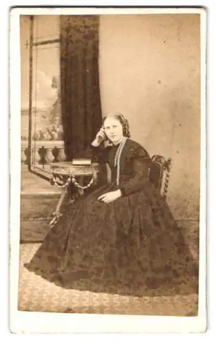 Fotografie A. Taylor, Chippenham, New Road, Frau in dunklem Kleid sitzend an Tisch mit Büchern