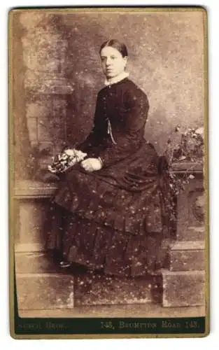 Fotografie Sutch Bros., London, Brompton Road 143, Porträt einer Dame in dunklem Kleid