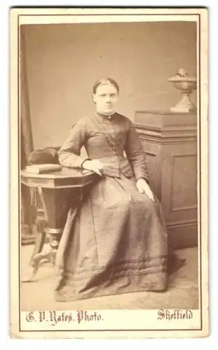 Fotografie G. V. Yates, Sheffield, Spital Hill 58, Frau sitzt an einem Tisch mit einem Hut