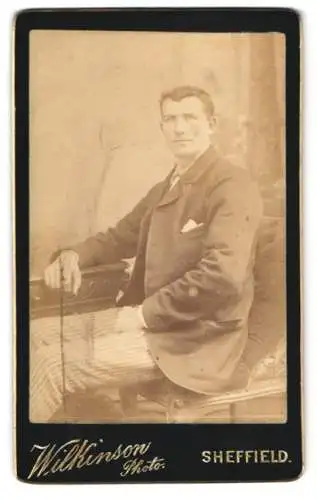 Fotografie Wilkinson Photo, Sheffield, Sitzender Herr in Anzug und gestreiften Hosen