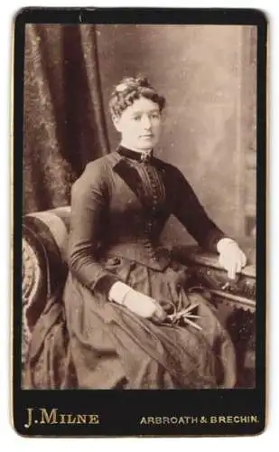 Fotografie J. Milne, Arbroath, Frau in elegantem Kleid mit Blumenzweig