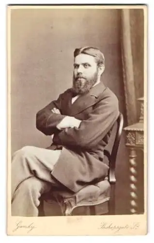 Fotografie Charles A. Gandy, London, Bishopsgate St. 5, Ein eleganter Herr mit Bart auf einem Stuhl sitzend