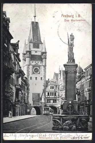 AK Freiburg i. B., Brunnen vor dem Martinsthor, eine Strassenbahn darunter