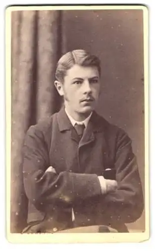 Fotografie E. Geering, Aberdeen, Union Place 10, Porträt eines jungen Mannes mit verschränkten Armen