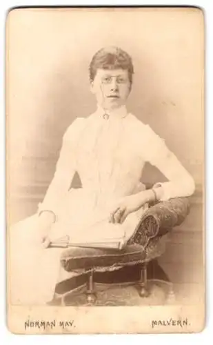 Fotografie Norman May, Malvern, Frau mit Brille und Buch in weissem Kleid