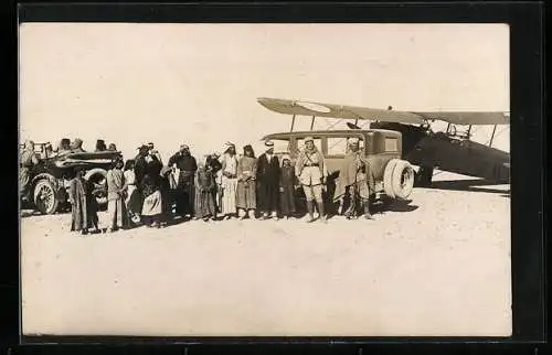 Foto-AK Französischer Soldat in der Wüste in Syrien mit Einheimischen, Autos und Flugzeug, Drusenrevolte