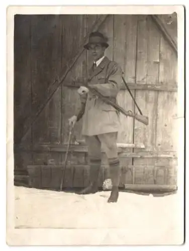 Fotografie Jäger mit Gewehr und Spazierstock im Schnee