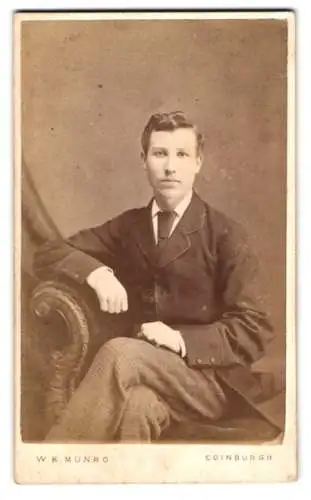 Fotografie W. K. Munro, Edinburgh, North Pitt Street, Porträt eines jungen Mannes auf einem Stuhl sitzend