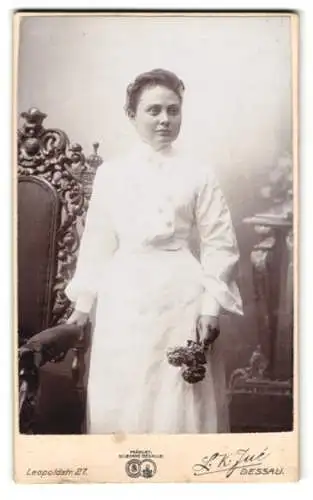 Fotografie L. K. Jue, Dessau, Leopoldstr. 27, Junge Frau in weissem Kleid mit Blumenstrauss