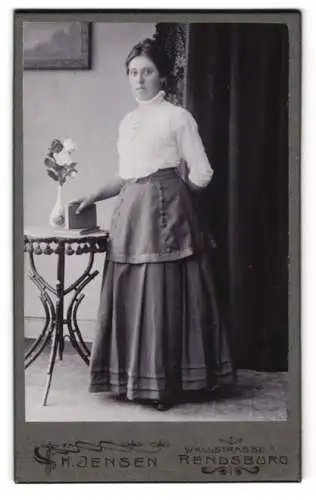 Fotografie H. Jensen, Rendsburg, Wallstrasse 1, Frau in eleganter Pose neben Tisch