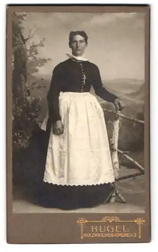 Fotografie Fritz Hugel, Holzkirchen, Frau in traditioneller Kleidung an einer rustikalen Balustrade