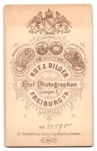 Fotografie Ruf & Dilger, Freiburg i. B., Ludwigstr. 2, Frau in eleganter Kleidung neben einem Stuhl