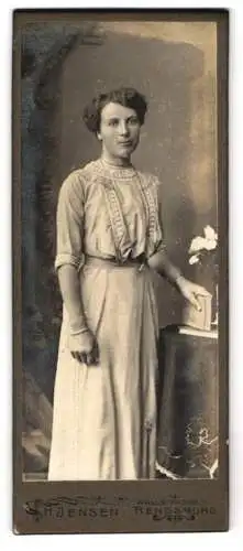 Fotografie H. Jensen, Rendsburg, Wallstrasse 1, Frau in eleganter Kleidung neben einem Tisch mit Blumen