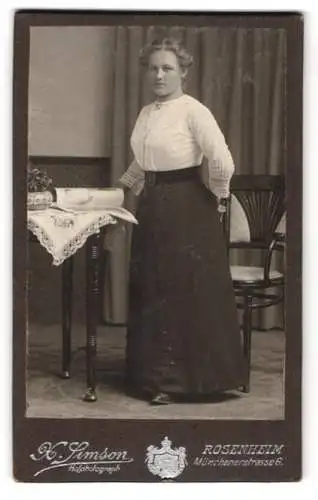 Fotografie X. Simson, Rosenheim, Münchenerstrasse 6, Frau in eleganter Pose neben einem Tisch