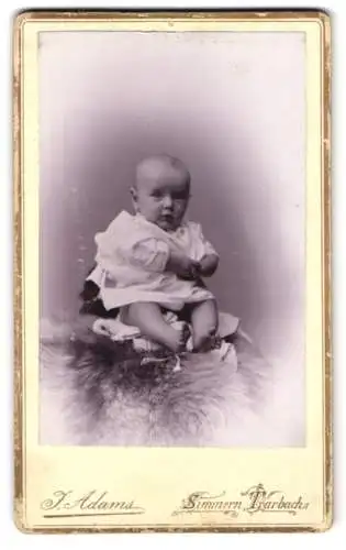 Fotografie J. Adams, Simmern, Baby auf Fell sitzend