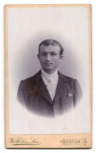 Fotografie Wilh. Lau, Hartha, Greif zeigt Wappenschild mit Monogramm des Fotografen, Portrait eines jungen Mannes