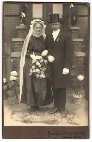 Fotografie H. Deike, Hannover-Linden, Deisterstrasse 7, Hochzeitspaar auf einem Fell vor dem Haus, schwarzes Kleid