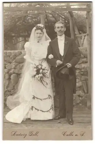 Fotografie Ludwig Goll, Calbe a. S., Ein junges Hochzeitspaar, sie im weissen Kleid mit eingesticktem Grün