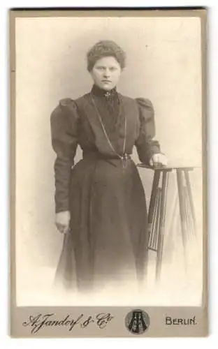 Fotografie A. Jandorf & Co., Berlin, Spittelmarkt 16 /17, Frau in viktorianischem Kleid mit Tisch