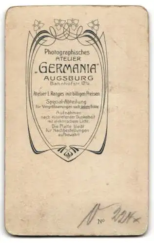 Fotografie Photographie Germania, Augsburg, Bahnhofstrasse 12½, Ein junger Mann steht neben einem verzierten Stuhl