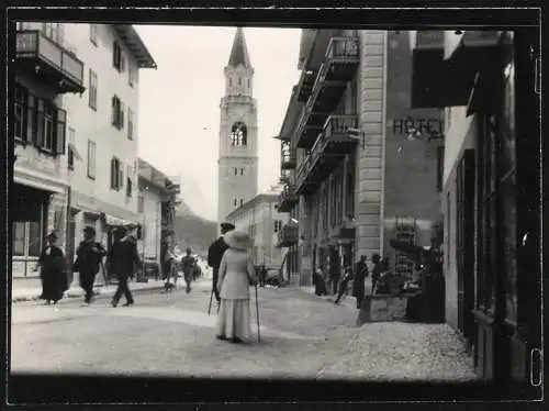 Fotografie unbekannter Fotograf, Ansicht Cortina d'Ampezzo, Strassenansicht mit Hotel und Kirchturm