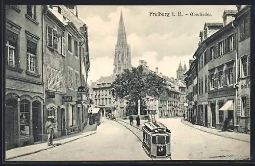 AK Freiburg i. Br., Oberlinden, Strassenpartie mit Strassenbahn und Kirche