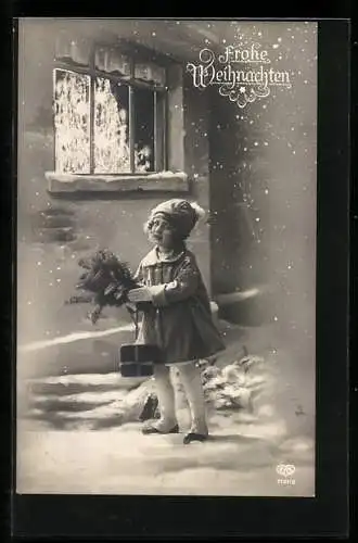 Foto-AK EAS Nr. 7121 /2: Frohe Weihnachten, Mädchen mit Tannenzweig und Geschenk vor einem Fenster stehend