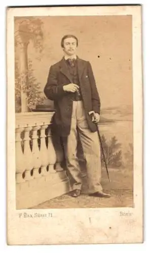 Fotografie F. Hax, Bonn, Junger Mann mit einem Gehstock und einem Kneifer in der Hand