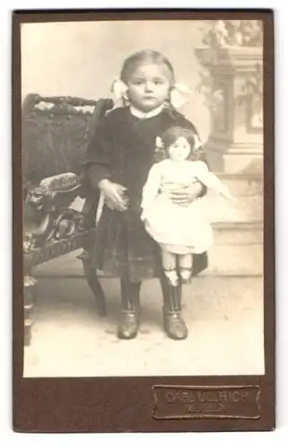 Fotografie Carl Ulrich, Mügeln, Junges Mädchen mit ihrer Puppe und Schleifen im Haar