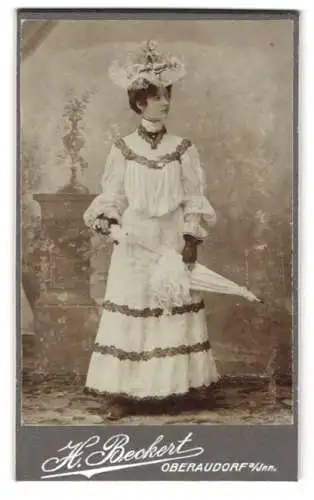 Fotografie H. Beckert, Oberaudorf a. Inn, Bürgerliche Dame im weissen Kleid mit dunklen Zierstreifen, Rüschenhut