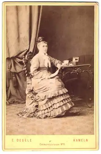 Fotografie C. Degèle, Hameln, Emmernstrasse 11, Marie Bode im gerafften Kleid mit einem Brief in der Hand