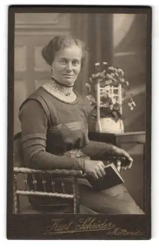 Fotografie Kurt Schröder, Mittweida, Frau mit Buch neben Blumenarrangement