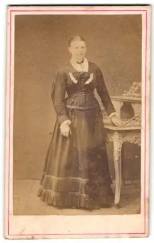 Fotografie E. Hundt, Calbe a. S., Schloss-Str. 14, Dame in eleganter Pose neben einem Tisch