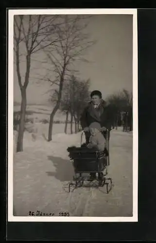 Foto-AK Frau mit Kind im Kinderwagen in einer Schneelandschaft