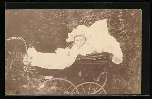 Foto-AK Lächelndes Kind sitzt im Kinderwagen