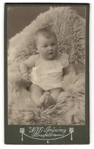 Fotografie W. Gröning, Harsefeld /Hannov., Ein Baby auf einem weichen Fell liegend