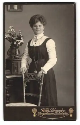 Fotografie Wilh. Schwabe, Langenhausen, Bahnhofstr., Stehende Dame mit Stuhl und Blumenarrangement