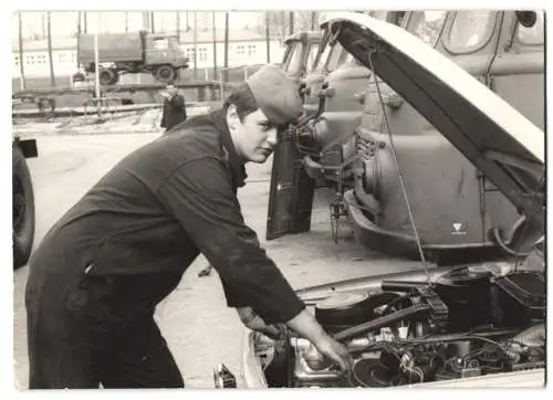 Fotografie Soldat / Mechaniker der NVA repariert Auto Wartburg 353 Kübelwagen, Lastwagen Robur im Hintergrund