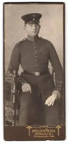 Fotografie Atelier Regis, Berlin, Prinzenstr. 44, Junger Soldat in Uniform auf kunstvollem Stuhl sitzend