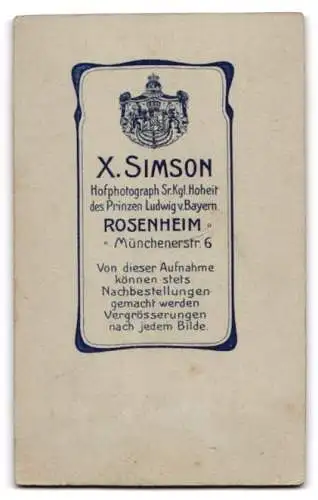 Fotografie X. Simson, Rosenheim, Münchenerstrasse 6, Soldat in Uniform neben einem Tisch