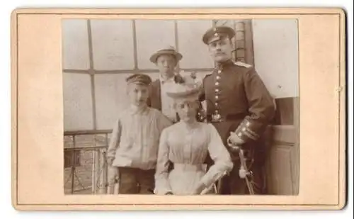 Fotografie unbekannter Fotograf und Ort, Ein Soldat mit Familie in einem lichtdurchfluteten Raum