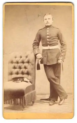 Fotografie Franz Kööp, Altona, Reichenstrasse 35, Soldat in Uniform an einem Sessel lehnend