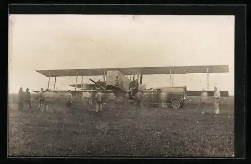 AK Militär-Doppeldeckerflugzeug mit geschäftigen Soldaten davor