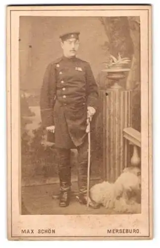 Fotografie Max Schön, Merseburg, Rossmarkt 2, Eisenbahner in Uniform mit Säbel und seinem Diensthund