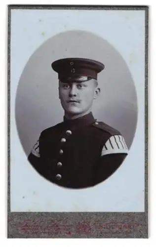 Fotografie Julius Stoess, Stuttgart, Soldat in Musiker Uniform mit Schwalbennest