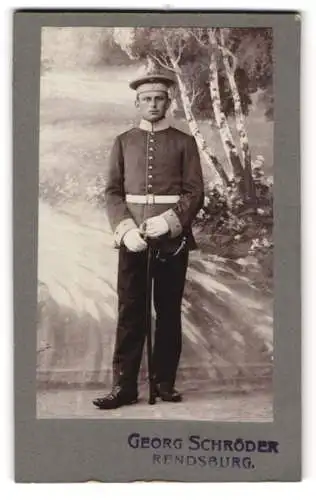 Fotografie Georg Schröder, Rendsburg, Soldat in Uniform mit Säbel vor einer Studiokulisse