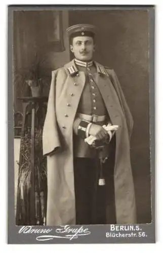 Fotografie Bruno Grupe, Berlin, Blücherstr. 56, Soldat in Garde Uniform mit Mantel und Säbel, Portepee