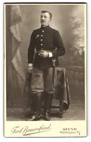 Fotografie Ferd. Bauernfeind, Steyr, K.u.K. Soldat in Uniform mit Schützenschnur und Bajonett