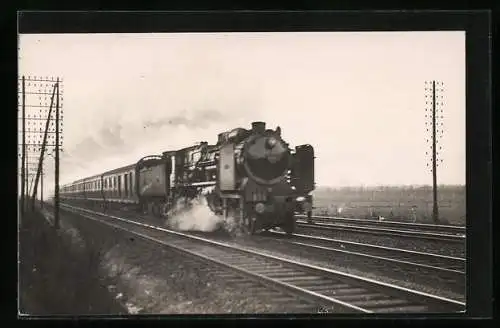 AK Eisenbahn mit Volldampf auf gerader Strecke, im Hintergrund eine Ortschaft